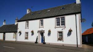 a white building with flowers on the windows at Thornhill Lodge, Historic 4 Bed, 4 Ensuite in Stirling