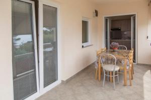 a dining room with a table and chairs and windows at Apartments Beba in Vir