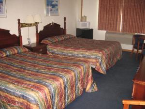 Habitación de hotel con 2 camas y ventana en Mackinaw Budget Inn, en Mackinaw City