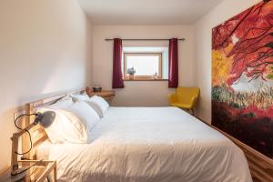 1 dormitorio con 1 cama con una pintura en la pared en Villa Alberta en Tenna 