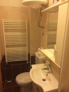 a bathroom with a sink and a toilet and a mirror at Studio Apartment Mala plaža in Kaštela