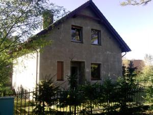 an old house with a fence in front of it at Cały dom do dyzpozycji in Boszkowo