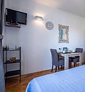 una camera da letto con tavolo e orologio sul muro di Apartments Marija a Supetar (San Pietro di Brazza)