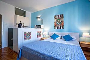 1 dormitorio azul con 1 cama con paredes azules en Apartments Marija en Supetar