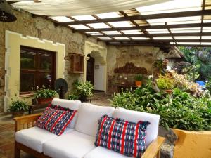 Casa Santa Rosa Hotel Boutique في أنتيغوا غواتيمالا: أريكة بيضاء مع وسادتين في الفناء