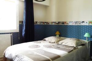 1 dormitorio con 1 cama grande y pared azul en Grand appart rez de chaussée, en Moulins
