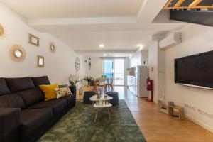 a living room with a couch and a tv at Ocean house in Ponta Delgada