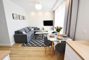 a living room with a couch and a table at Apartament Baltic Pearl in Kołobrzeg