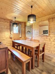 uma sala de jantar em madeira com uma mesa de madeira e bancos em Chalet Le Renard Du Lac em Les Gets