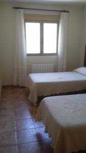 a room with two beds and a window at Casas Valleiruelas in Las Cruceras