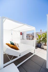 a white canopy bed on a balcony with plants at Candelaria10 in Cádiz