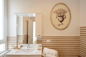 La salle de bains est pourvue d'un lavabo et d'un miroir. dans l'établissement Affittacamere My Home, à Livourne