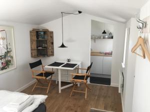 una pequeña cocina con mesa y sillas en una habitación en Cozy Guesthouse en Gilleleje