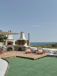 a patio with two chairs and a table on a deck at Maria Seaview Villa in Naousa