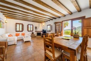 uma sala de estar com uma mesa e um sofá em Villa Romero I em Es Cubells