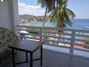 a balcony with a table and a view of the ocean at Bellevue Resort in Puerto Galera