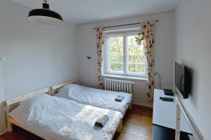 um quarto com 2 camas, uma televisão e uma janela em Mostek 32 Silent Apartment em Gdansk