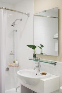 a bathroom with a tub, sink, and mirror at The Gardens Sonesta ES Suites New York in New York