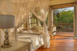 a bedroom with a bed with a canopy at Panzi Lodge in Guernsey Nature Reserve