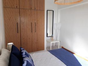 a bedroom with a bed and a large wooden closet at Atlantico 8- Vista Mar, Ar-Condicionado, 80mt Praia, Wifi in Quarteira