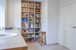 a book shelf in a kitchen with a sink at Near park apartment with balcony in Birštonas