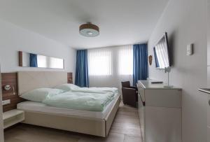 クックスハーフェンにあるStrandhaus Christiansenのベッドとデスクが備わるホテルルームです。