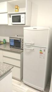 a white kitchen with a refrigerator and a microwave at Amazing Studio Apartment in Buenos Aires