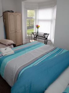 a large bed in a room with a table at Alphalink Apartment in Middlesbrough