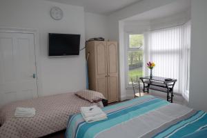 a bedroom with a bed and a table and a television at Alphalink Apartment in Middlesbrough