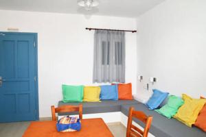een woonkamer met een bank en kleurrijke kussens bij Anemoessa Studios in Serifos Chora
