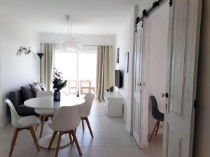a white dining room with a white table and chairs at Atlantico 8- Vista Mar, Ar-Condicionado, 80mt Praia, Wifi in Quarteira
