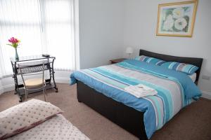 a bedroom with a bed and a table with a chair at Alphalink Apartment in Middlesbrough