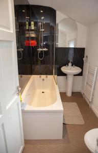a bathroom with a bath tub and a sink at Alphalink Apartment in Middlesbrough +66 photos