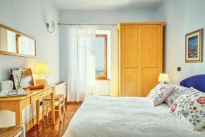 a bedroom with a bed and a desk and a window at B&B Daria Monticchiello in Monticchiello