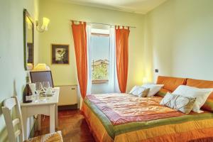 a bedroom with a bed and a table and a window at B&B Daria Monticchiello in Monticchiello