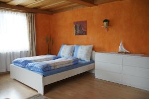 ein Schlafzimmer mit einem Bett mit orangefarbenen Wänden in der Unterkunft Ferienwohnungen Klose in Gosau