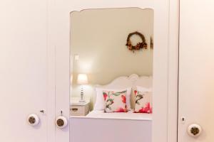 sypialnia z białym łóżkiem z lustrem w obiekcie Ermoupolis 1834 Classic beauty w mieście Ermupoli
