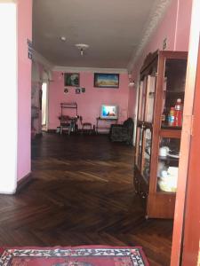 sala de estar con paredes de color rosa y suelo de madera. en Hostel Luz Robles, en Quito