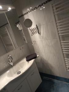 uma casa de banho branca com um lavatório e um espelho em Ferienwohnung Zechner em Waidring