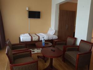 pokój hotelowy z łóżkiem, stołem i krzesłami w obiekcie Esikar Gardens Hotel w mieście Narok