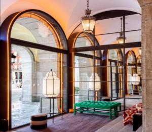 a room with a green bench in front of windows at Pestana Plaza Mayor Madrid in Madrid