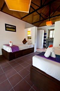 a bedroom with two beds and a tiled floor at Raingsey Bungalow in Kep
