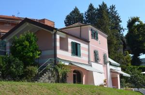 una casa rosa en una colina con árboles en RosMarino, en Celle Ligure