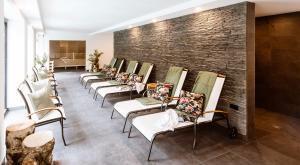a row of chairs lined up against a brick wall at Parkhotel Hohnstein by STEIGER Hotels in Hohnstein