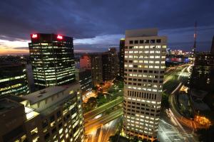 un profilo della città con edifici alti e traffico notturno di The York by Swiss-Belhotel a Sydney