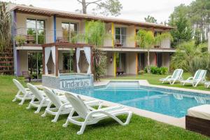 a villa with a swimming pool and lounge chairs at Undarius Hotel (exclusively gay men) in Punta del Este