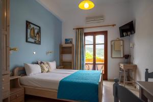 a bedroom with a bed with a blue blanket at Eleni Goumenaki Plakias Studios in Plakias