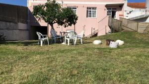 a table and chairs in the yard of a house at Garden Hostel in Aradas