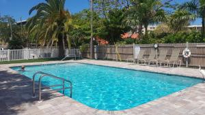 a large swimming pool with chairs in a yard at Siesta Key Condo - on the water ! in Siesta Key