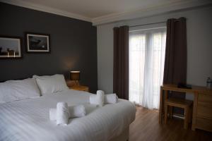 1 dormitorio con 1 cama blanca grande con almohadas blancas en The Mortimer Arms, en Romsey